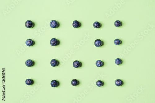 Pattern of fresh blueberries in on pastel green background. Healthy breakfast concept