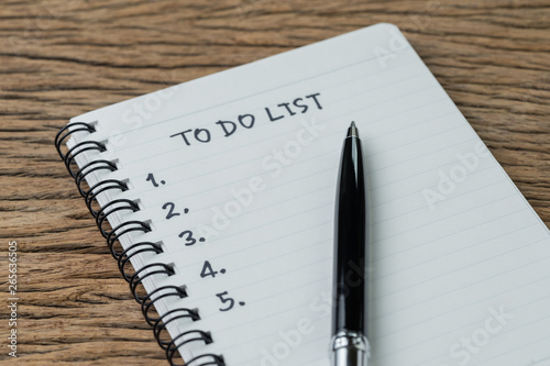 To do list, checklist of things or tasks to complete for life habit, business project plan concept, black pen on notepad with handwriting headline To do list and list of numbers on wooden table