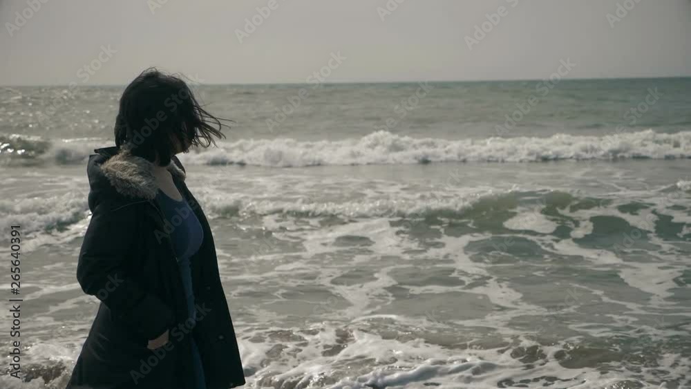lonely pensive young woman walking on the beach in winter day- slow motion lonely pensive young woman walking on the beach in winter day- slow motion