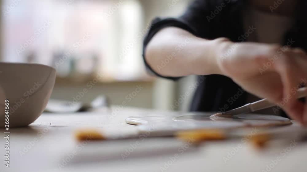 close up female ceramist preparing brush and paint for decor close up female ceramist preparing brush and paint for decor