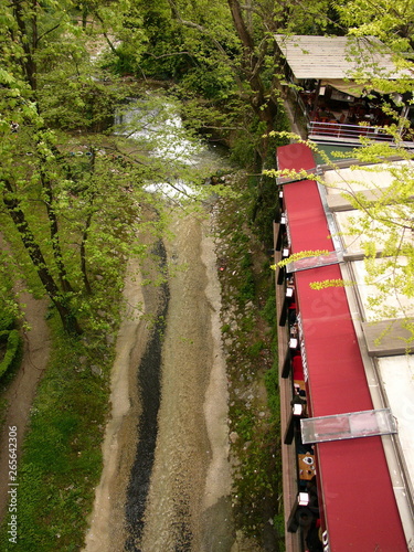 Blick von einer Brücke auf den Lauf des Gökdere Fluss mit grüner Parkanlage und Café in einem Tal in der ehemaligen osmanischen Hauptstadt Bursa am Uludag Gebirge in der Türkei photo