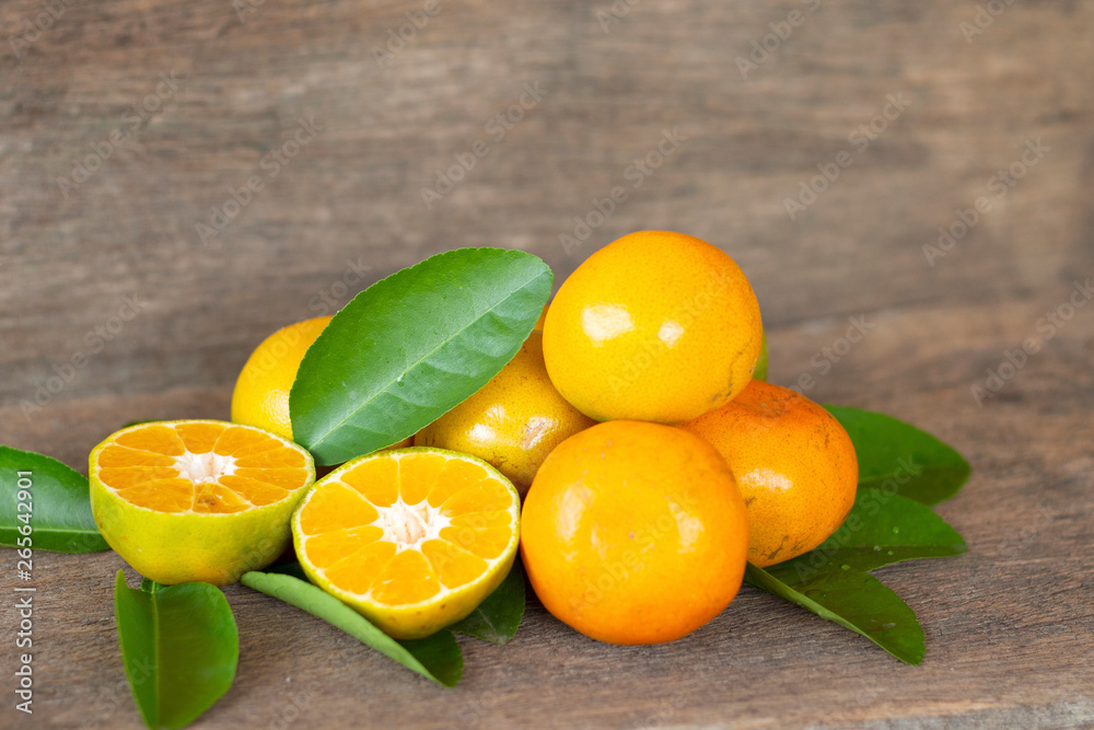  Ripe oranges and leaves on a wooden table, separate on the old wooden floor, sour fruit