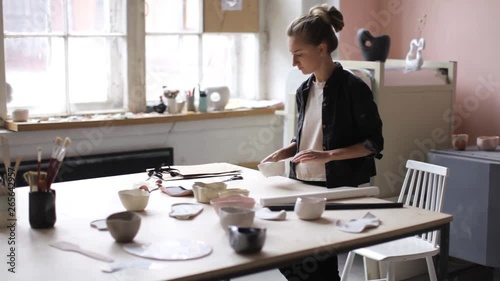 Wallpaper Mural woman is packing a ceramic plate while standing in the workshop Torontodigital.ca