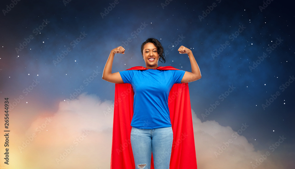super power and people concept - happy african american young woman in superhero red cape over starry night sky and clouds background super power and people concept - happy african american young woman in superhero red cape over starry night sky and clouds background