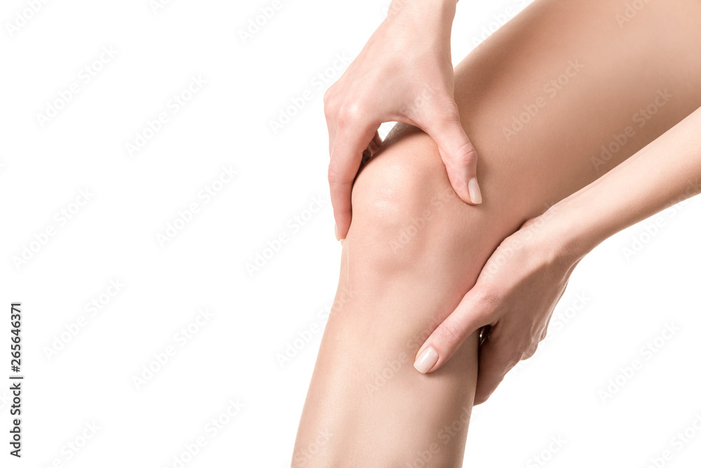 Female injured knee joint. Woman suffered her leg and touches her sore spot by hands. Well groomed skin, close up, isolated on white