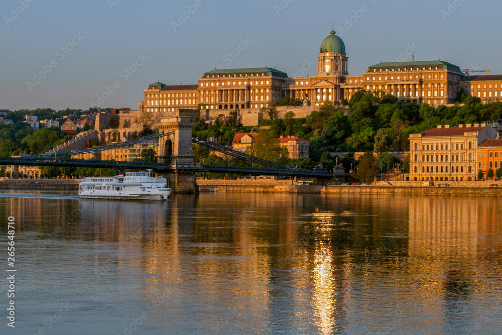 View at the Royal Castle of Budapest and the Szechenyi Chain Bridge. Center of Budapest and the River Dunayyat in the morning. In foreground pleasure boat. Hungary. European travel.