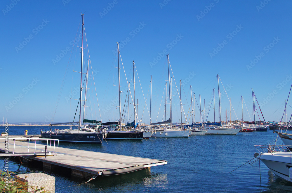 Yacht club with snow-white ships on the pier in the lagoon in the port.