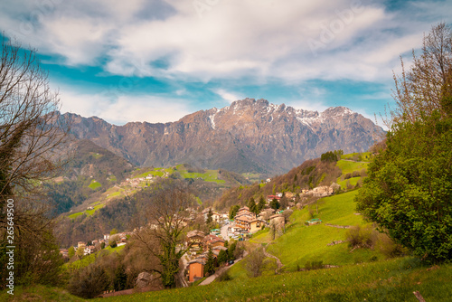 Landscape of green hills in Orobie mountains,background view of mountain peaks in spring time with snow, Seriana valley near Bergamo,Lombardy,italy