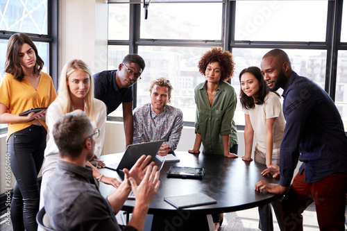 Creative business team listening to colleague at a brainstorm meeting