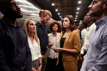 Business people standing in office elevator