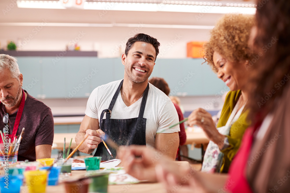 Group Of Mature Adults Attending Art Class In Community Centre
