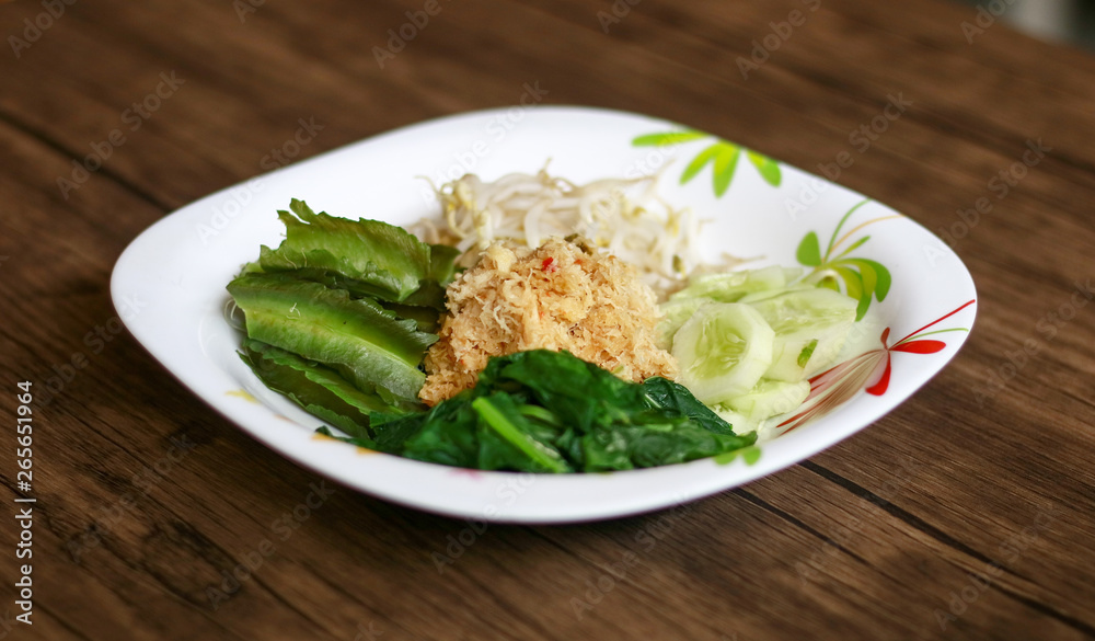 Sayur urap on wood background.  Cooked vegetables with spiced grated coconut. Indonesian traditional food.