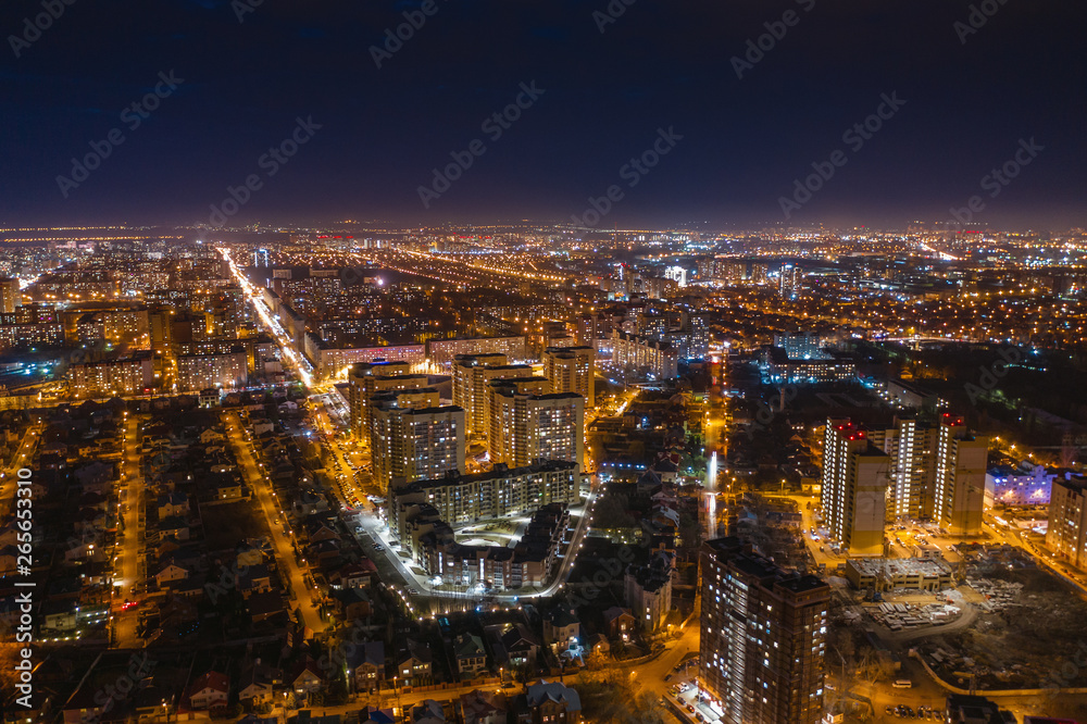 Aerial cityscape panoramic view, flight on drone above night city Voronezh with illuminated roads and high-rise buildings