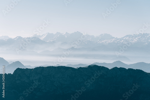 Scenic view of silhouettes of mountains in the morning mist