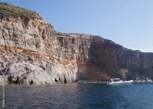 View of the white and yellow mountains of the cliffs growing from the sea on the shore from a boat. Blue Lagoon.