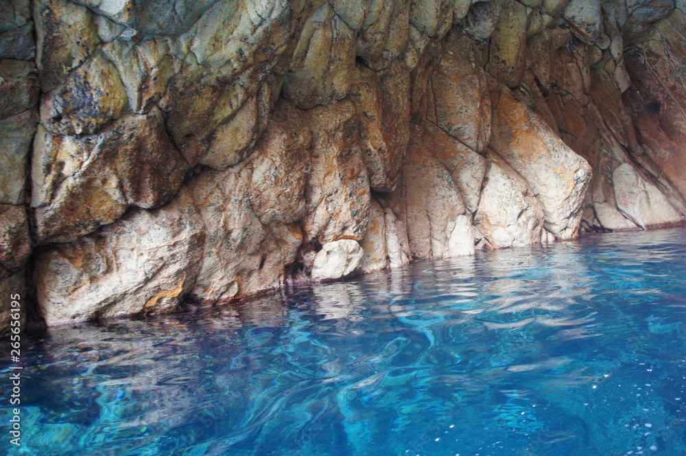 Grotto in the lagoon with azure blue transparent water with stones and rocks. Grotto in the lagoon with azure blue transparent water with stones and rocks.