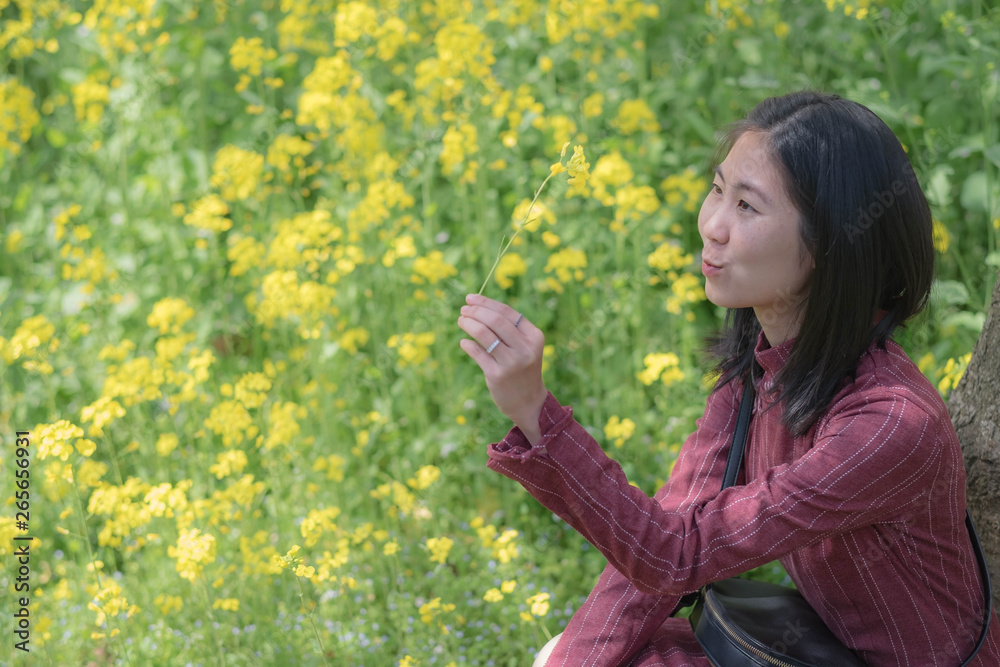 Φωτογραφία Unspecific woman looking at the yellow flower in her hand at the east lake park