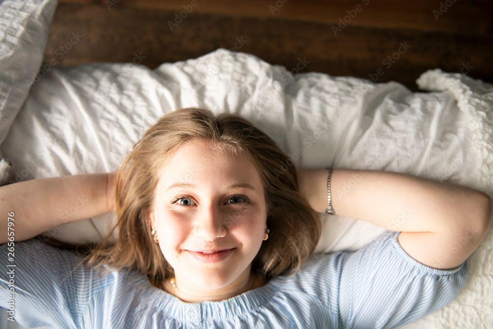 A teenage girl lying in bed and relaxing A teenage girl lying in bed and relaxing