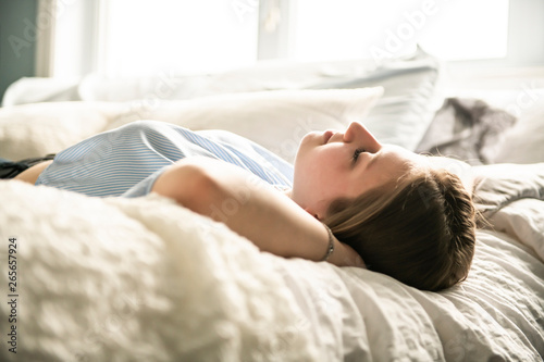 A teenage girl lying in bed and relaxing