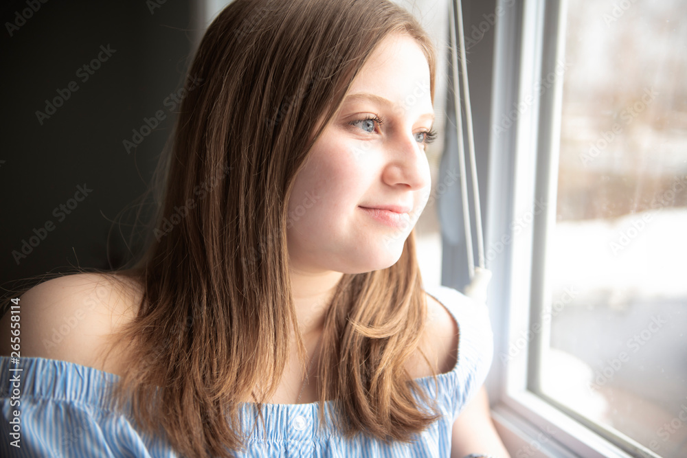 Portrait of a beautiful young teenager girl near window Portrait of a beautiful young teenager girl near window