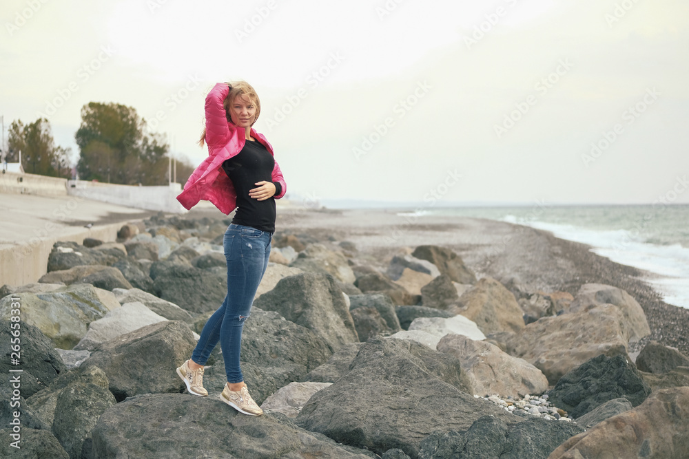 Beautiful blond girl posing for photo on sea coast