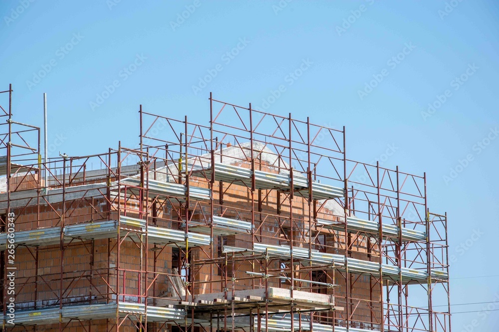 Facade of an apartment under construction with scaffoldings