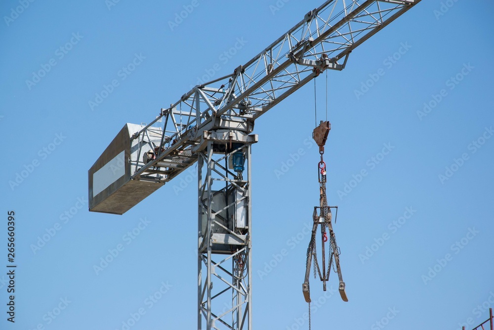 Detail of a construction crane lifting construction equipment