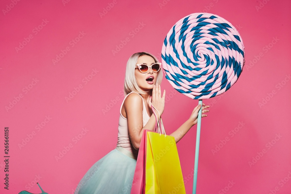Cute model with sweets and shopping bags
