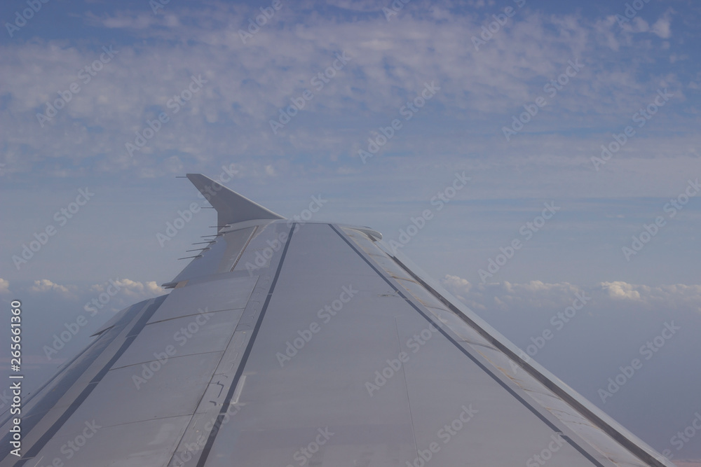 wing of airplane flying above clouds wing of airplane flying above clouds