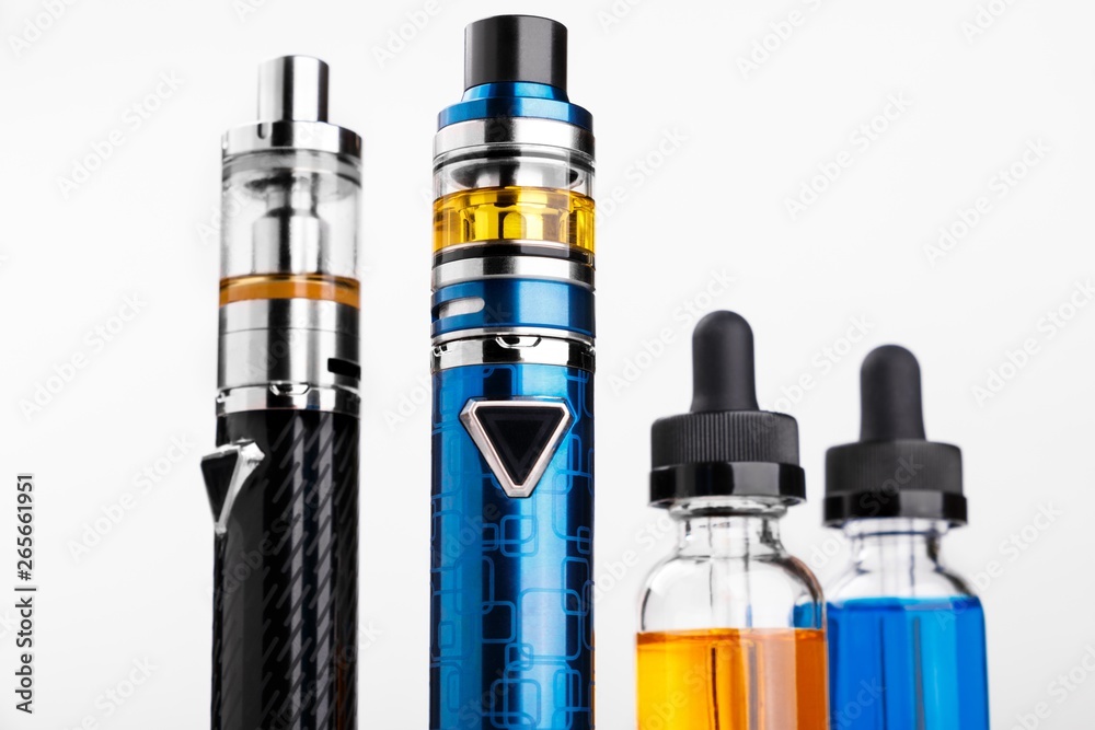 Electronic cigarettes and bottles with vape liquid on white background Electronic cigarettes and bottles with vape liquid on white background