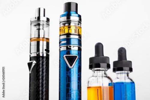Electronic cigarettes and bottles with vape liquid on white background