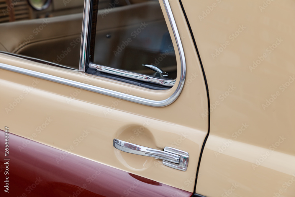 View on closed rear door with handle and corner wondow of the old Russian retro vintage car of the executive class released in the Soviet union in beige and brown. Auto service industry.
