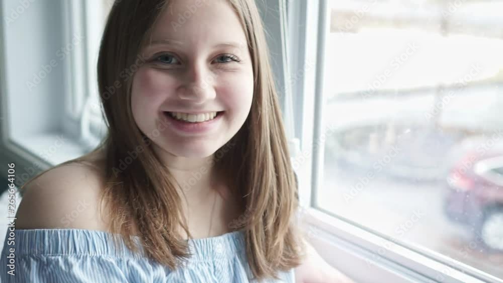 A Portrait of a beautiful young teenager girl near window A Portrait of a beautiful young teenager girl near window