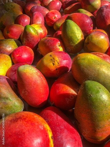 Ripe red mangos are heaped at market ready for sale