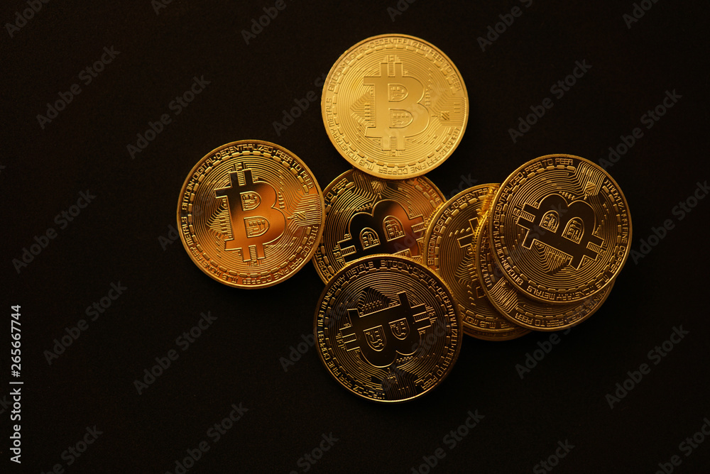 Crypto curency bitcoin gold coins on a black background. Crypto curency bitcoin gold coins on a black background.