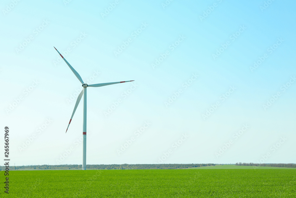 Wind turbine in a green grass field, space for text. Beautiful spring greenery Wind turbine in a green grass field, space for text. Beautiful spring greenery