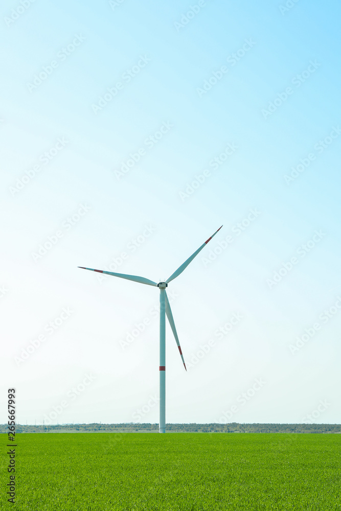 Wind turbine in a green grass field, space for text. Beautiful spring greenery Wind turbine in a green grass field, space for text. Beautiful spring greenery