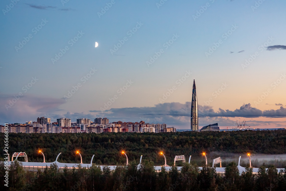 Obraz premium Evening cityscape. View of the Lakhta Center tower in St. Petersburg in the sunset with clouds and moon