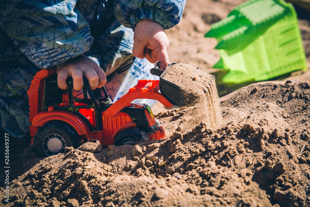 custom made wallpaper toronto digitallittle child playing with a red excavator in a sandbox
