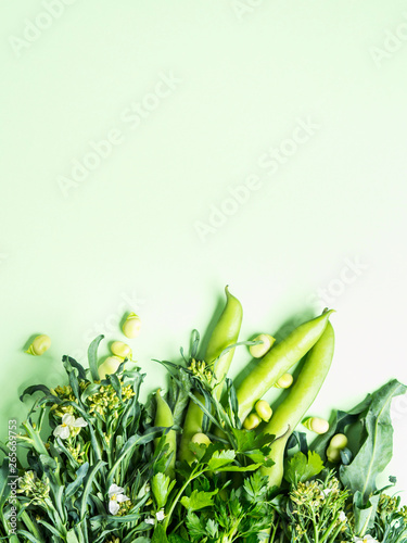 Green vegetables and herbs on pastel background. Monochrome. Healthy organic food concept.