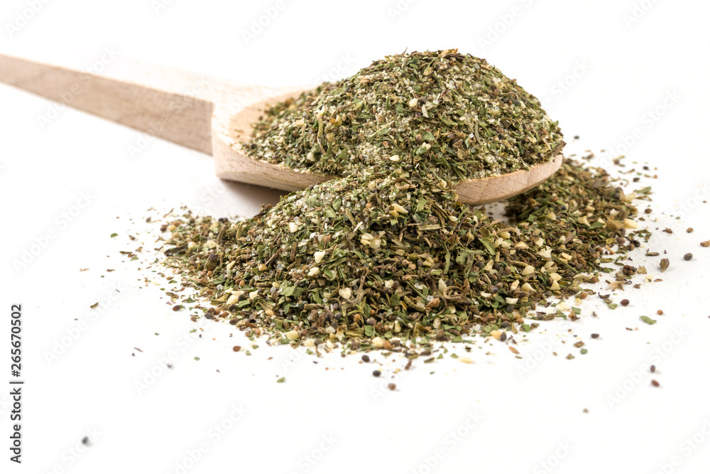 green savory mix or Chubritsa on wooden spoon on white background green savory mix or Chubritsa on wooden spoon on white background