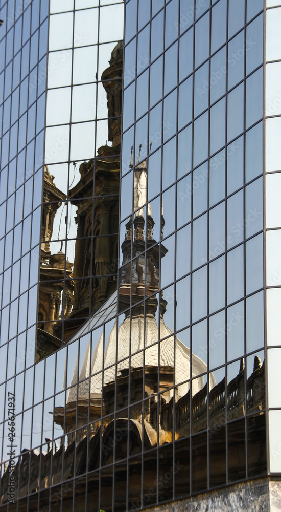 Fototapeta premium Reflexo de um predio na parede de vidro do outro lado da rua em Santiago