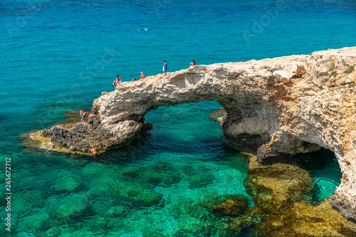 CYPRUS, THE BRIDGE OF LOVERS - MAY 11/2018: Tourists jump from a height into the azure waters of the Mediterranean Sea.