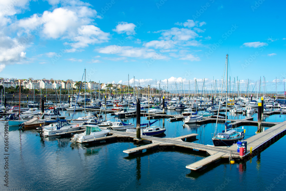 Yachts  and motorboats docked at marina in Bangor. Sailboat Harbor against blue sky