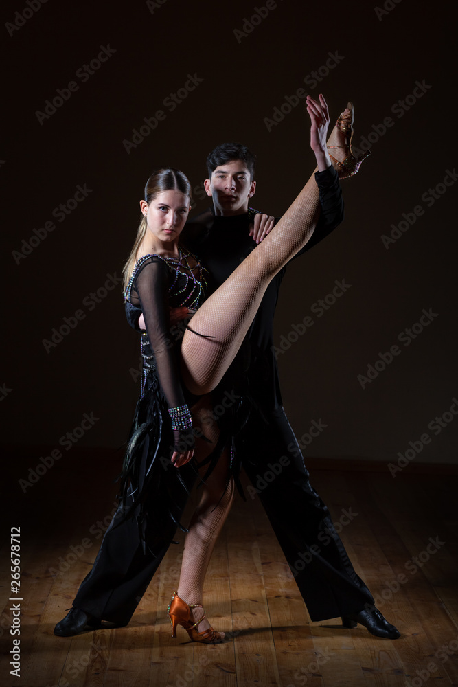 Beautiful young dancers in ballroom isolated on black background Beautiful young dancers in ballroom isolated on black background