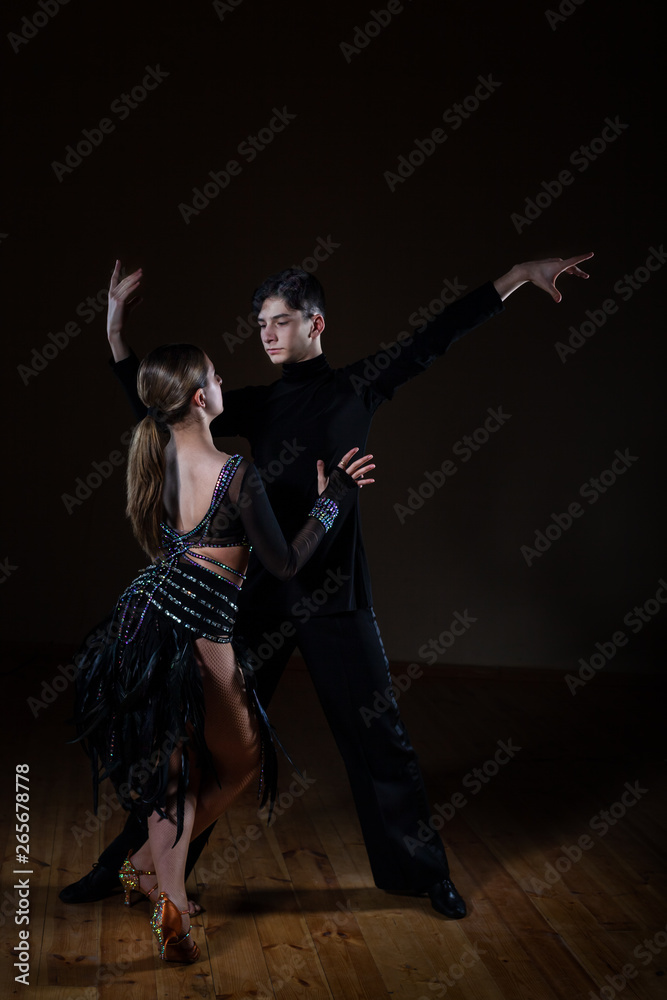 Beautiful young dancers in ballroom isolated on black background Beautiful young dancers in ballroom isolated on black background