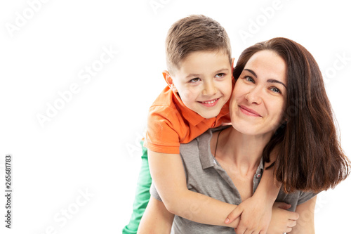 Mom and son hug and smile. White background.