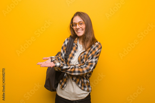 Young student woman holding something with hands