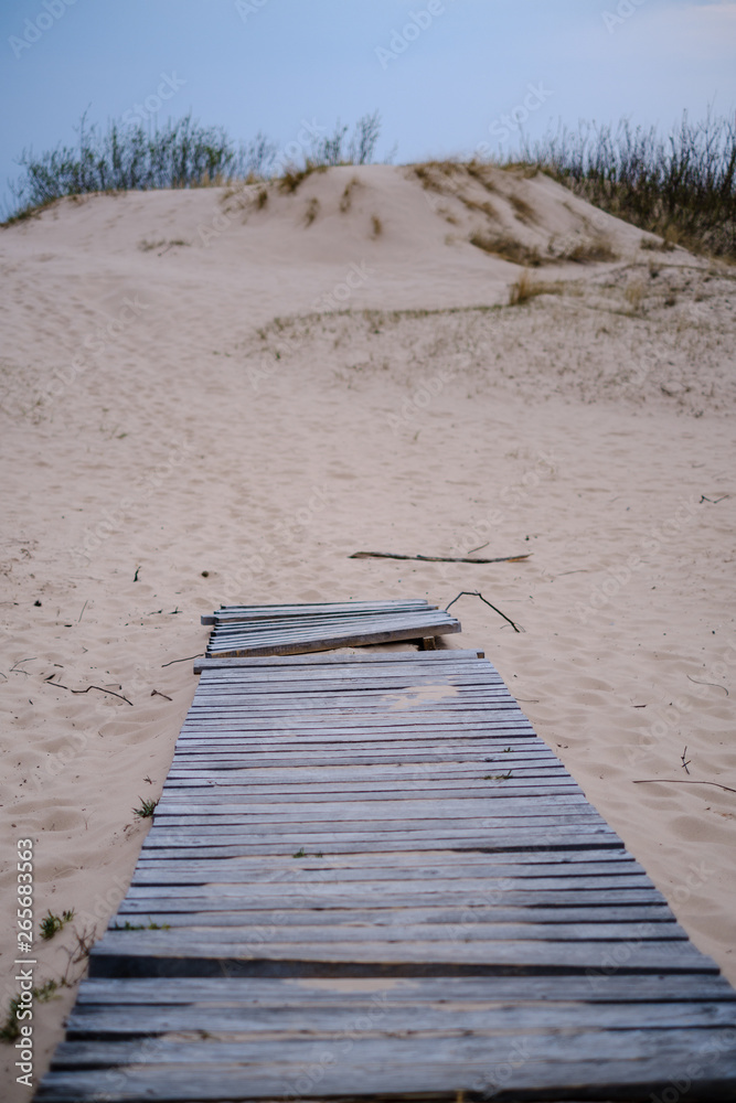 wooden plank boardwalk near sea in the dunes