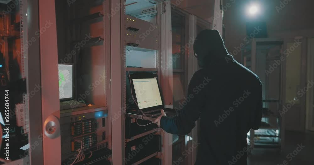 Masked hacker shuts down computer disconnects wire Masked hacker shuts down computer disconnects wire